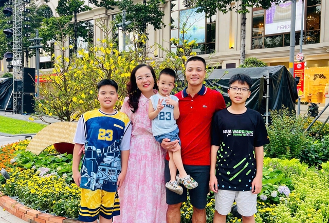 Gia đ&igrave;nh miền Bắc v&agrave;o TP.HCM ăn tết: Ấn tượng mai v&agrave;ng ngập lối - Ảnh 1.