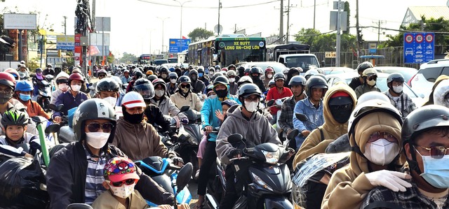 Người đ&agrave;n &ocirc;ng lặng lẽ dọn đường, tiếp sức d&ograve;ng người trở về TP.HCM sau tết- Ảnh 1.