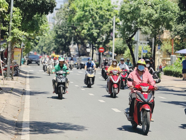 Thời tiết TP.HCM nắng n&oacute;ng, người d&acirc;n che k&iacute;n từ đầu đến ch&acirc;n khi ra đường - Ảnh 2.