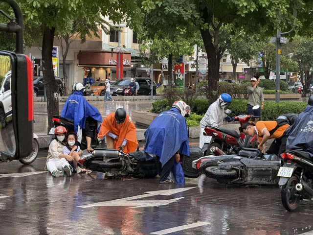 Trời mưa, nhiều xe trượt ngã trên phố đi bộ Nguyễn Huệ- Ảnh 1.