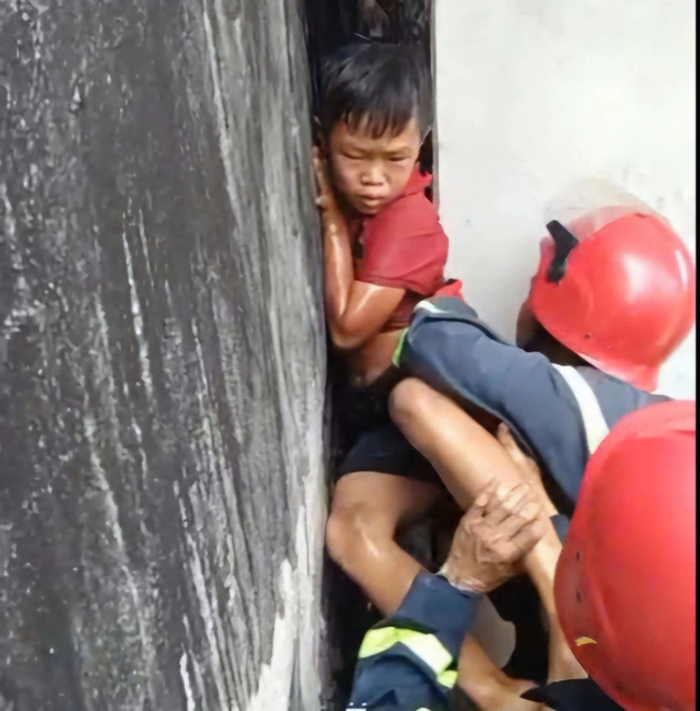 TP.HCM: Cảnh s&aacute;t PCCC giải cứu an to&agrave;n b&eacute; trai kẹt giữa hai bức tường hẹp - Ảnh 1.
