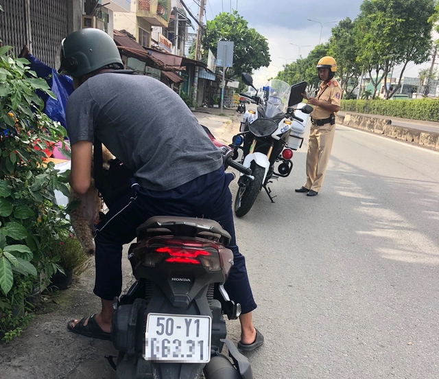 Ngại đường v&ograve;ng, xe m&aacute;y liều đi ngược chiều quốc lộ bị CSGT TP.HCM xử phạt - Ảnh 1.