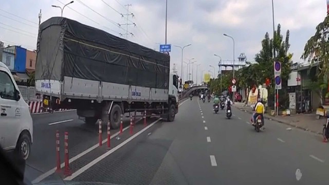 Xe tải bất chấp tất cả, cán qua cọc tiêu để chuyển làn gây bức xúc - Ảnh 1.