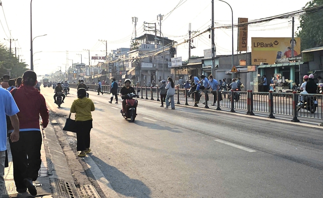 TP.HCM: C&ocirc;ng nh&acirc;n liều m&igrave;nh leo dải ph&acirc;n c&aacute;ch băng qua tỉnh lộ 8 - Ảnh 1.