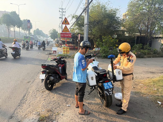 CSGT lập bi&ecirc;n bản phạt người chạy xe m&aacute;y v&agrave;o l&agrave;n &ocirc; t&ocirc; - Ảnh 1.