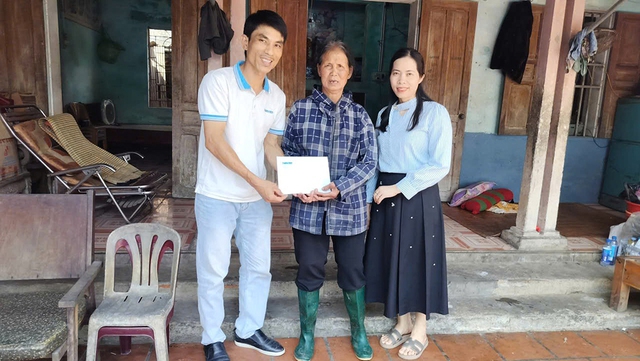 Trao tiền của bạn đọc cho cụ bà nuôi 3 người tâm thần- Ảnh 1.