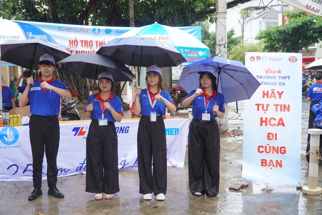 Bất chấp mưa đổ xối xả, tình nguyện viên che mưa tiếp sức thí sinh - Ảnh 1.