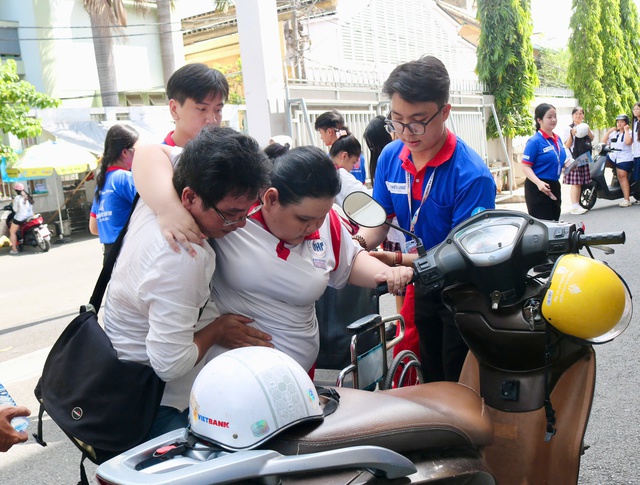 Cảm động hình ảnh nữ sinh ngồi xe lăn đến điểm thi được hỗ trợ hết lòng - Ảnh 2.