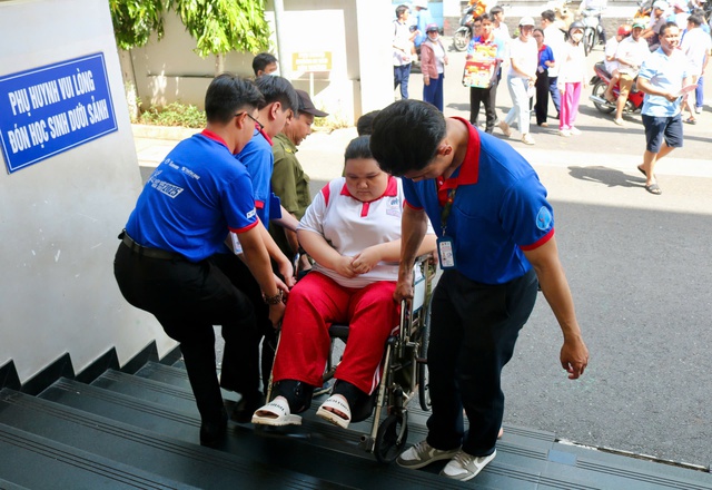 Cảm động hình ảnh nữ sinh ngồi xe lăn đến điểm thi được hỗ trợ hết lòng - Ảnh 1.