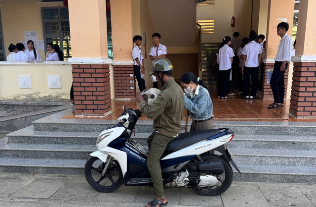 Thí sinh lớn tuổi được chồng đưa đón, đến phòng thi bằng nạng- Ảnh 1. Thí sinh lớn tuổi được chồng đưa đón, đến phòng thi bằng nạng- Ảnh 1.
