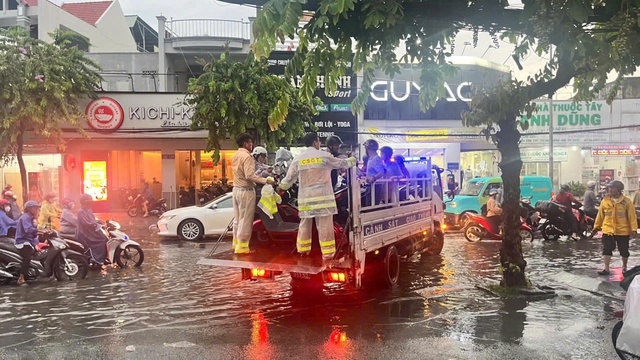 CSGT d&ugrave;ng xe đặc chủng chở người d&acirc;n vượt đường ngập s&acirc;u giữa mưa lớn ở TP.HCM - Ảnh 2.
