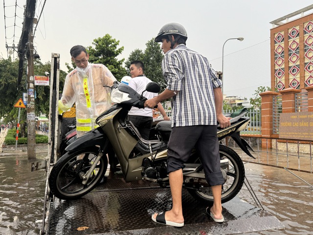 CSGT d&ugrave;ng xe đặc chủng chở người d&acirc;n vượt đường ngập s&acirc;u giữa mưa lớn ở TP.HCM - Ảnh 3.
