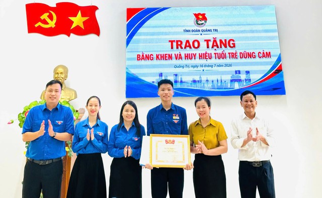 Trao huy hiệu Tuổi trẻ dũng cảm cho nam sinh lao ra biển cứu hai trẻ em- Ảnh 1.