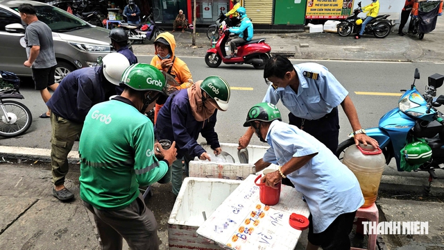 Thùng nước miễn phí ấm lòng người lao động giữa nắng gắt TP.HCM - Ảnh 2.
