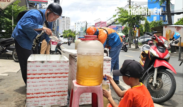 Thùng nước miễn phí ấm lòng người lao động giữa nắng gắt TP.HCM - Ảnh 1.