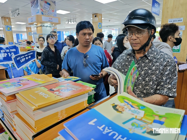 Học sinh TP.HCM tựu trường, nhà sách vẫn đông nghịt người tìm sách giáo khoa sáng nay - Ảnh 9.
