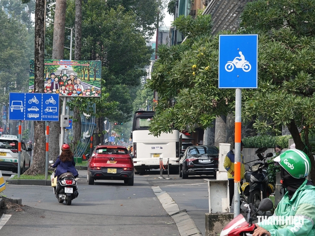 Gặp làn đường xe máy có dải phân cách, ô tô tấp vào đón khách thế nào? - Ảnh 1.