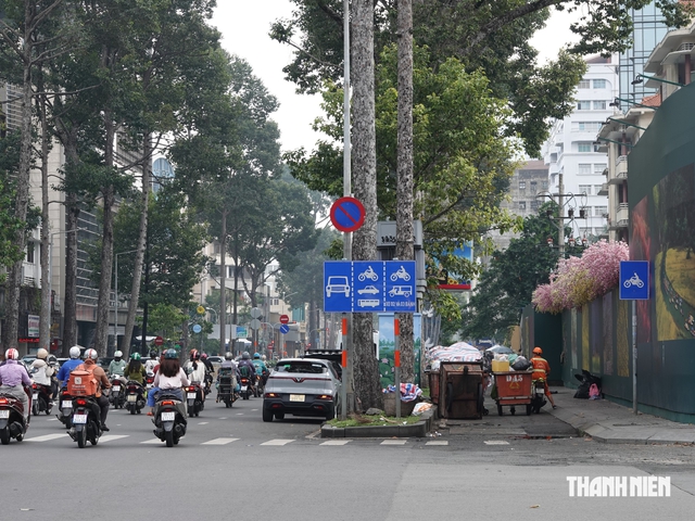 Gặp làn đường xe máy có dải phân cách, ô tô tấp vào đón khách thế nào? - Ảnh 2.