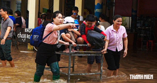 Giáo viên đẩy xe đưa học sinh qua vùng ngập - Ảnh 1.