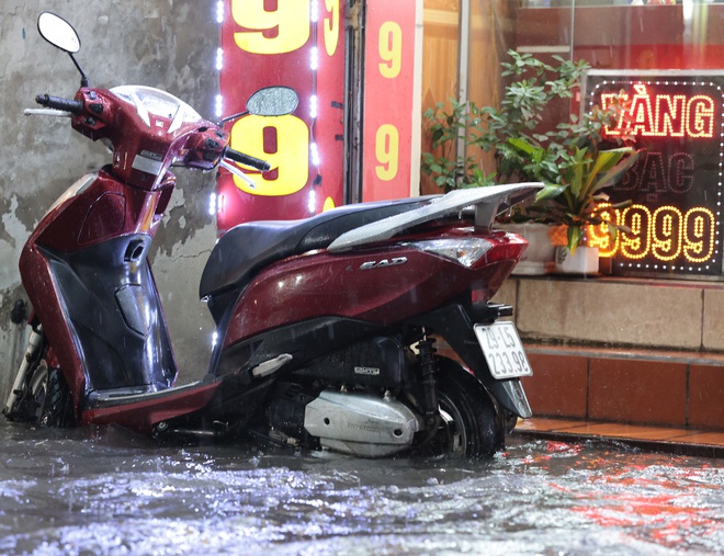 Đường phố Hà Nội ngập sâu sau cơn mưa lớn, phương tiện 'bơi' trong biển nước - Ảnh 11.