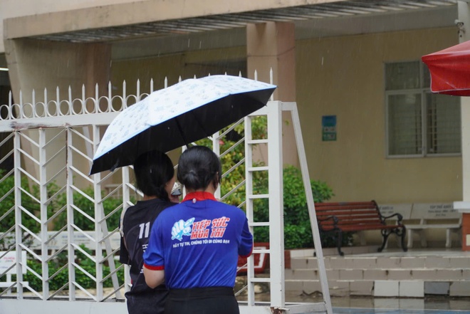 Bất chấp mưa đổ xối xả, tình nguyện viên che mưa tiếp sức thí sinh - Ảnh 11.