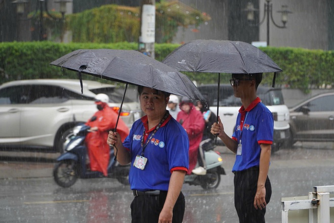 Bất chấp mưa đổ xối xả, tình nguyện viên che mưa tiếp sức thí sinh - Ảnh 17.