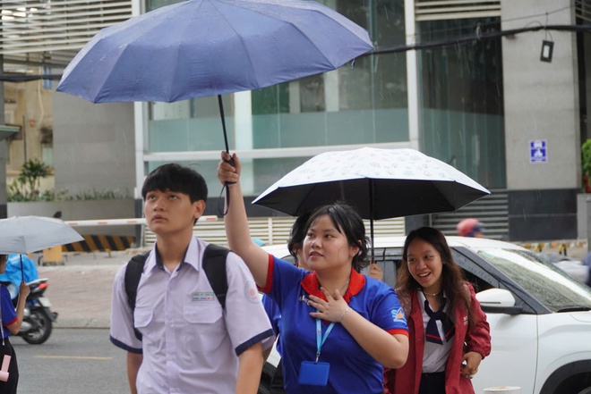 Bất chấp mưa đổ xối xả, tình nguyện viên che mưa tiếp sức thí sinh - Ảnh 19.
