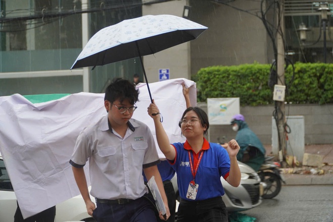 Bất chấp mưa đổ xối xả, tình nguyện viên che mưa tiếp sức thí sinh - Ảnh 8.