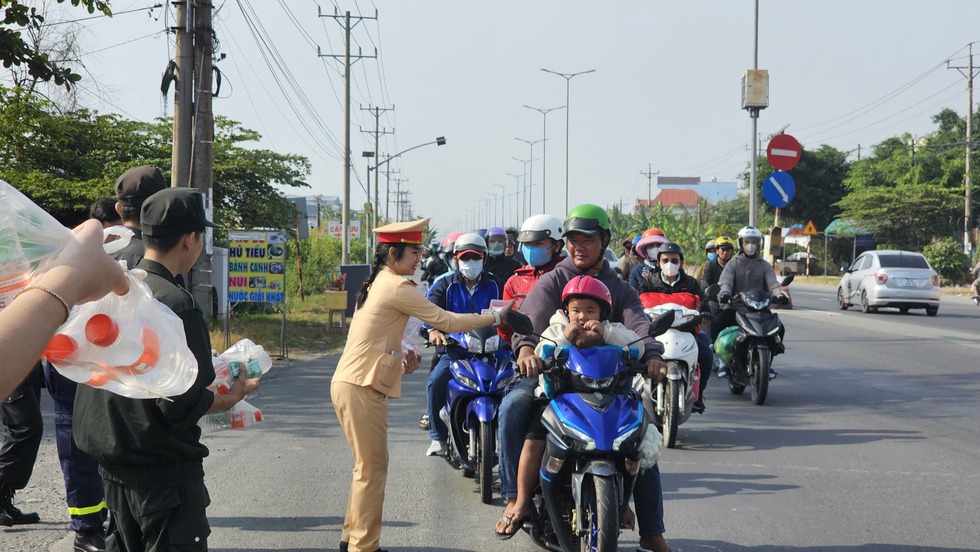 Cảnh sát Vĩnh Long tặng nước suối, sữa cho người dân rời quê mùng 4 tết- Ảnh 1.