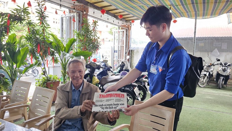 Tình nguyện viên tranh thủ 'gặm bánh mì', túc trực tiếp sức thí sinh - Ảnh 1.