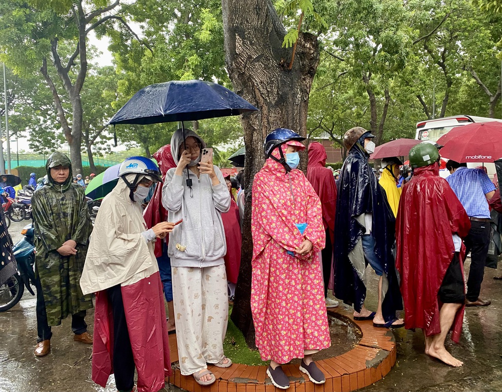 Xúc động hình ảnh nhiều phụ huynh đứng dưới trời mưa lớn hàng giờ đồng hồ đợi con - Ảnh 1.