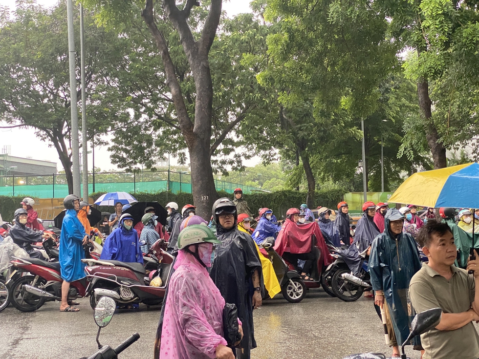Xúc động hình ảnh nhiều phụ huynh đứng dưới trời mưa lớn hàng giờ đồng hồ đợi con - Ảnh 2.