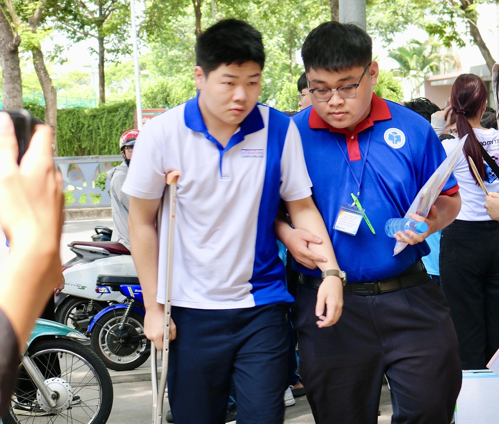 Nam sinh chống nạng bước v&agrave;o ph&ograve;ng thi bằng sự tiếp sức của những người xa lạ- Ảnh 2.