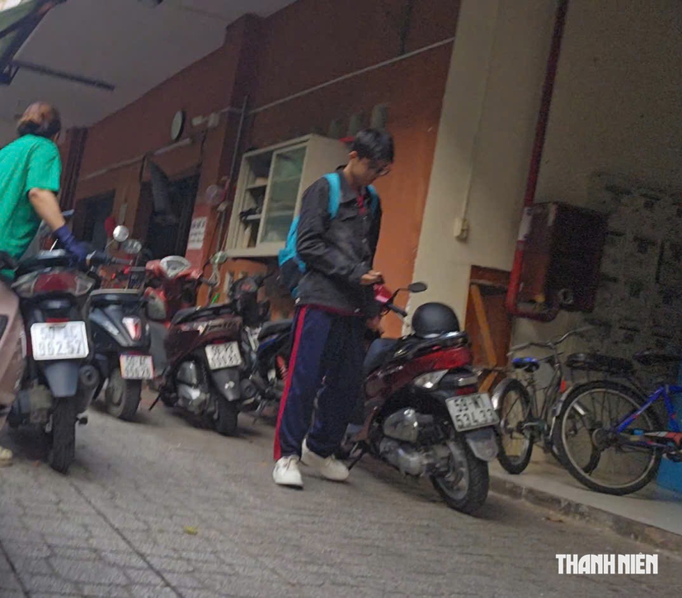 Học sinh ở TP.HCM đi xe máy: Gửi xe bên ngoài rồi đi bộ vào lớp- Ảnh 2.