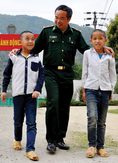 Thiếu tá Lò Văn Nguyệt và hai con nuôi - Ảnh: Mai Thanh Hải