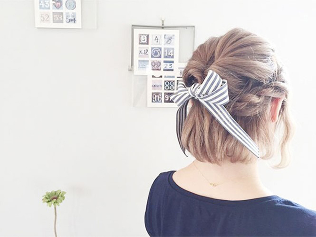 Lựa chọn kiểu tóc tết nửa đầu và sử dụng nơ làm điểm nhấn cho tóc