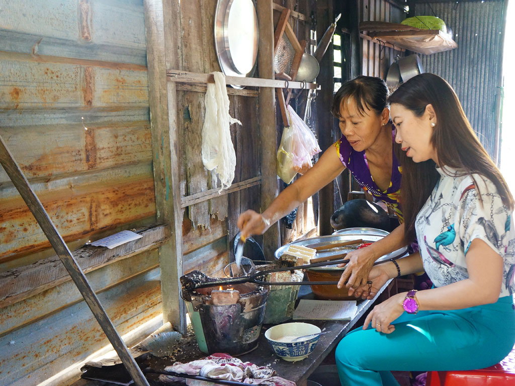 Chị Ngân hướng dẫn du khách làm bánh kẹp cuốn - Ảnh: Bách Hợp