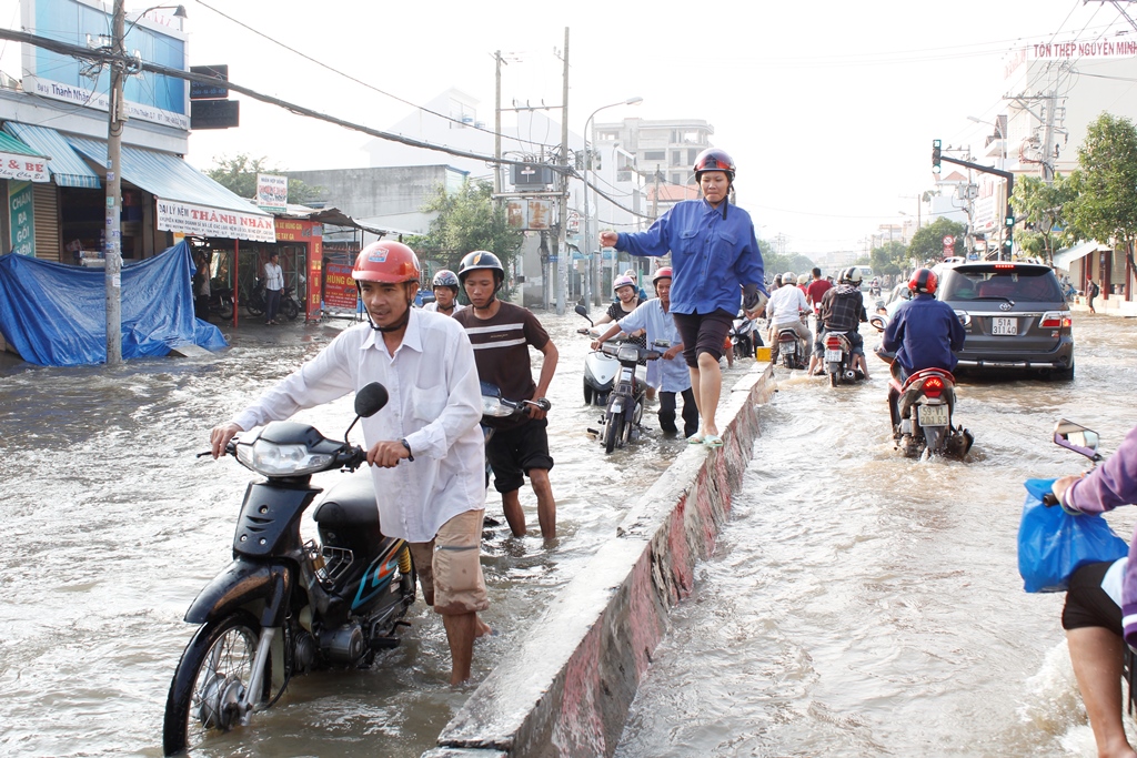 Người dân ở quận 7 đi lại hết sức khó khăn khi triều cường dâng cao. Ảnh chụp ngày 10.11.2014 - Ảnh: Phạm Hữu