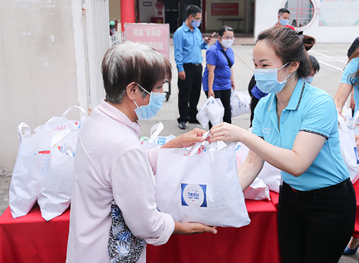 Bà Văn Thị Anh Thư, Phó tổng giám đốc cấp cao phụ trách Nhân sự - Công ty khát Suntory PepsiCo Việt Nam (phải) trao túi thực phẩm hỗ trợ người có hoàn cảnh khó khăn