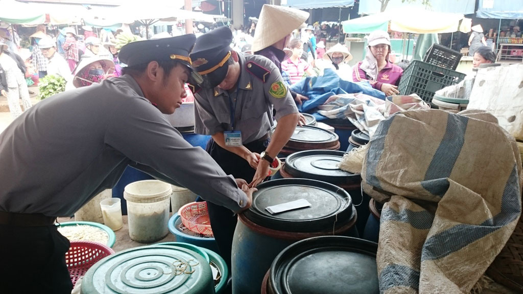 Cơ quan chức năng tiến hành niêm phong 15 thùng nhựa chứa khoảng 1 tấn măng của tiểu thương Trần Thị Xuân (chợ Đông Hà).