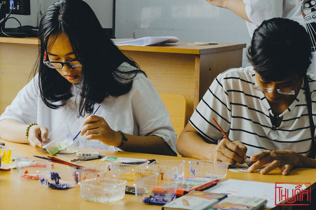 Các bạn trẻ hào hứng tham gia workshop vẽ trang trí đế lót li kiểu gạch bông theo phong cách retro, trong triển lãm Ở trên màu ngọc của nhóm Thuần - Ảnh: BTC cung cấp.
