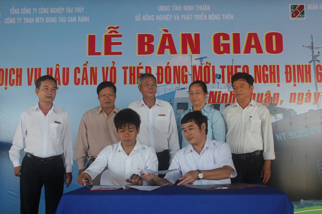 Ngư dân trẻ Dương Văn Thắng (ngồi bên trái) ký kết biên bản bàn giao tàu vỏ thép Hoàng Sa - Ảnh: Thiện Nhân
