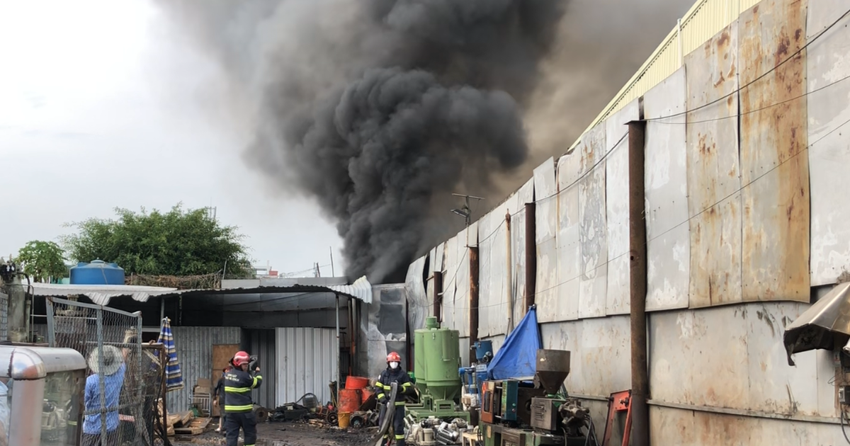 Cháy xưởng phế liệu ở TP.HCM, cảnh sát leo mái tôn dùng vòi rồng dập lửa