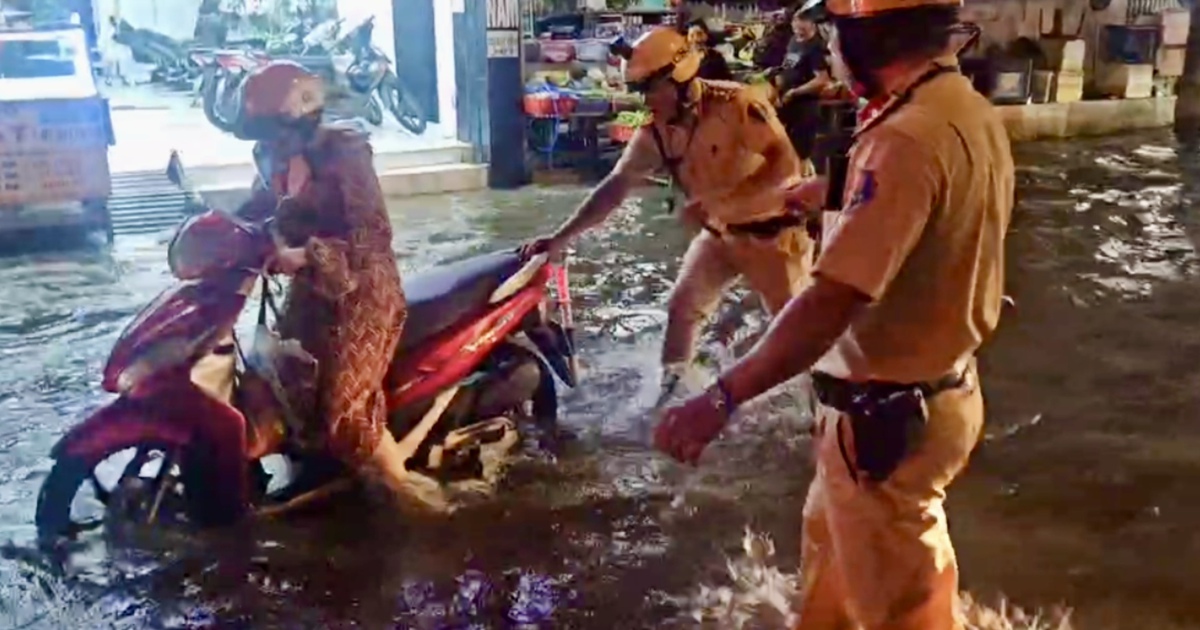 CSGT TP.HCM lội nước gi&uacute;p người d&acirc;n qua v&ugrave;ng ngập do triều cường