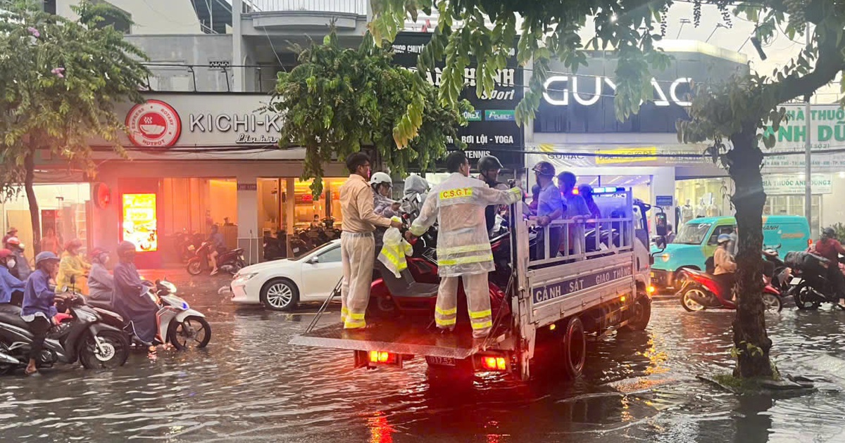 CSGT dùng xe đặc chủng chở người dân vượt đường ngập sâu giữa mưa lớn ở TP.HCM