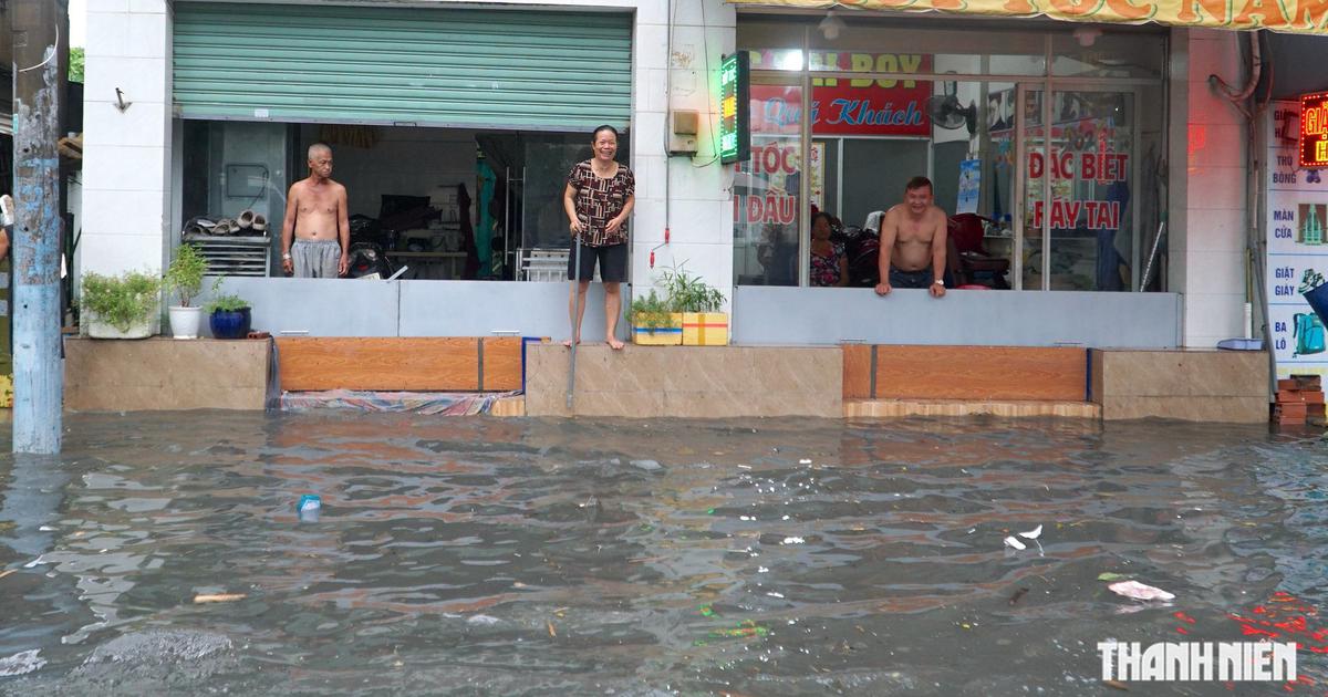Mưa lớn ở TP.HCM chiều 15.7: Nhiều tuyến đường ngập s&acirc;u, người d&acirc;n vất vả dọn b&ugrave;n r&aacute;c