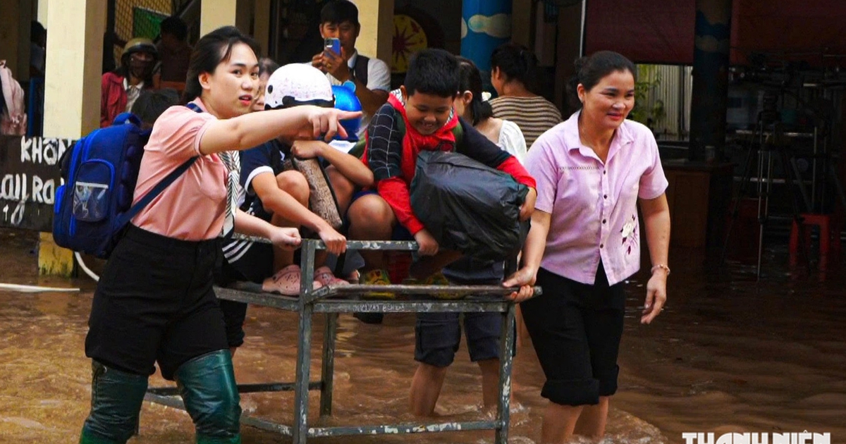 Gi&aacute;o vi&ecirc;n đẩy xe đưa học sinh qua v&ugrave;ng ngập