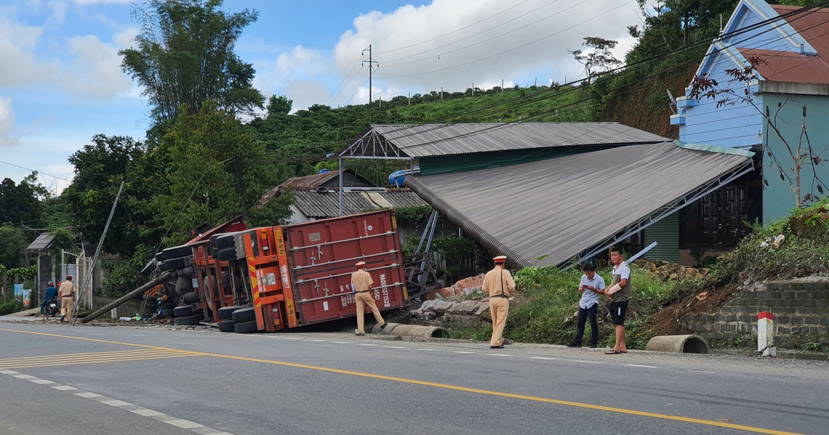 Xe container mất lái, lật nghiêng ủi sập tường rào, mái che 2 nhà dân