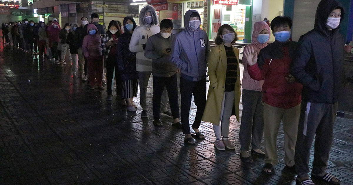 Giữa mưa rét, người dân vẫn xếp hàng đợi mua khẩu trang giá gốc trong đêm