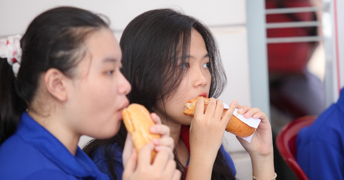 Thanh niên tình nguyện ăn vội bánh mì để tiếp sức mùa thi
